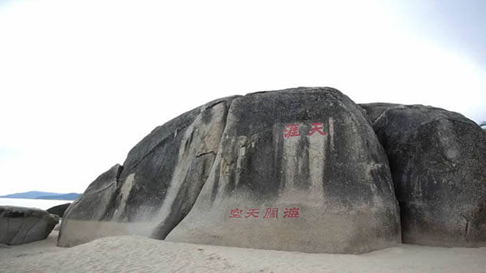 a large rock sitting on top of a sandy beach 