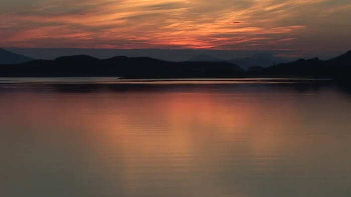 a landscape of a sunset near a lake