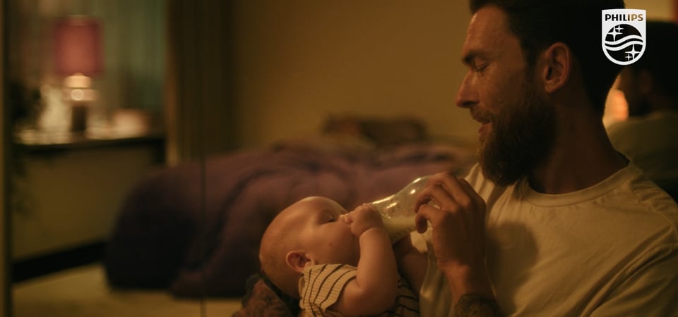 Seorang pria memberi makan bayi dengan botol